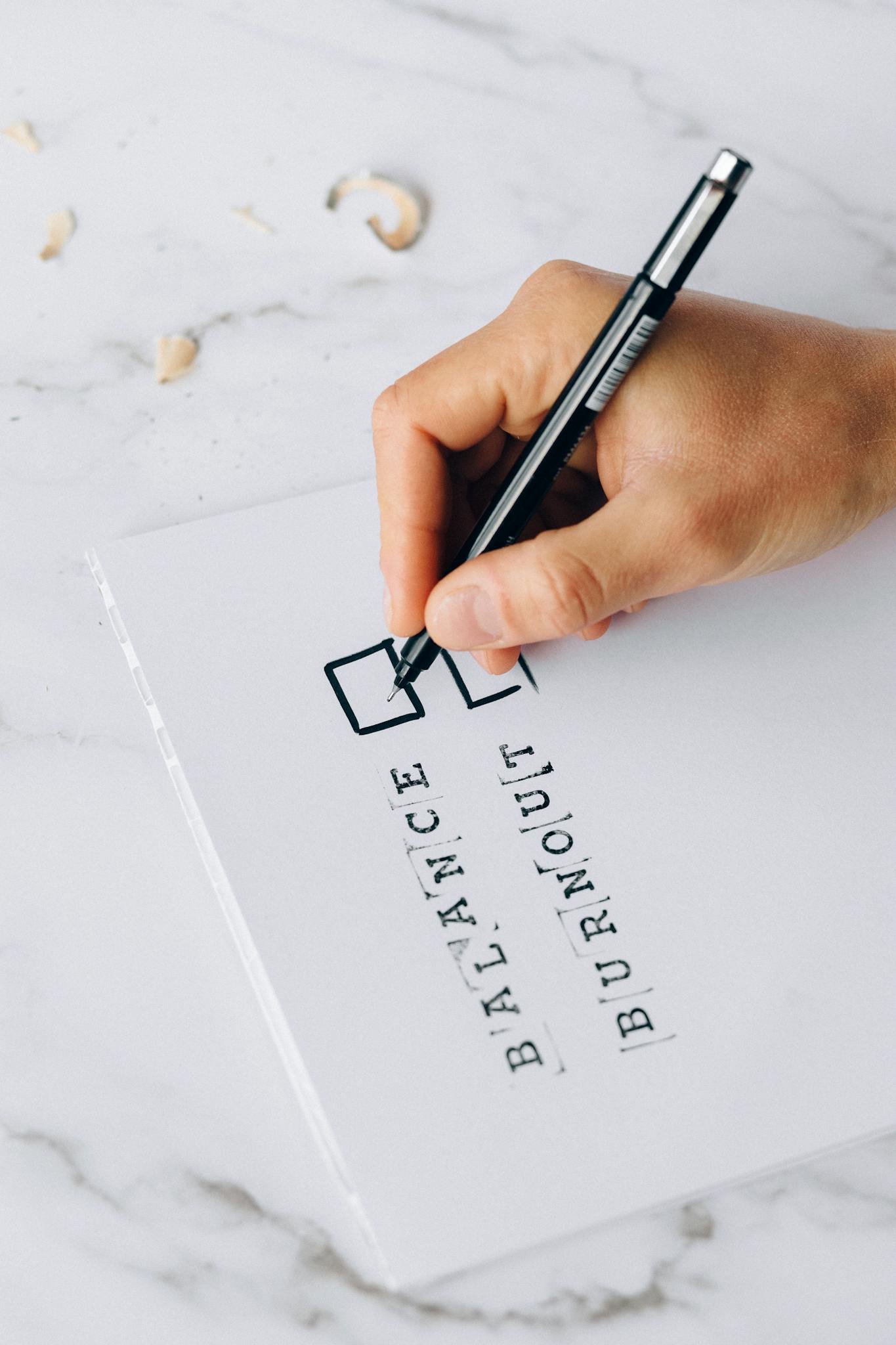 A hand checking balance or burnout on a checklist, symbolizing life balance decisions.